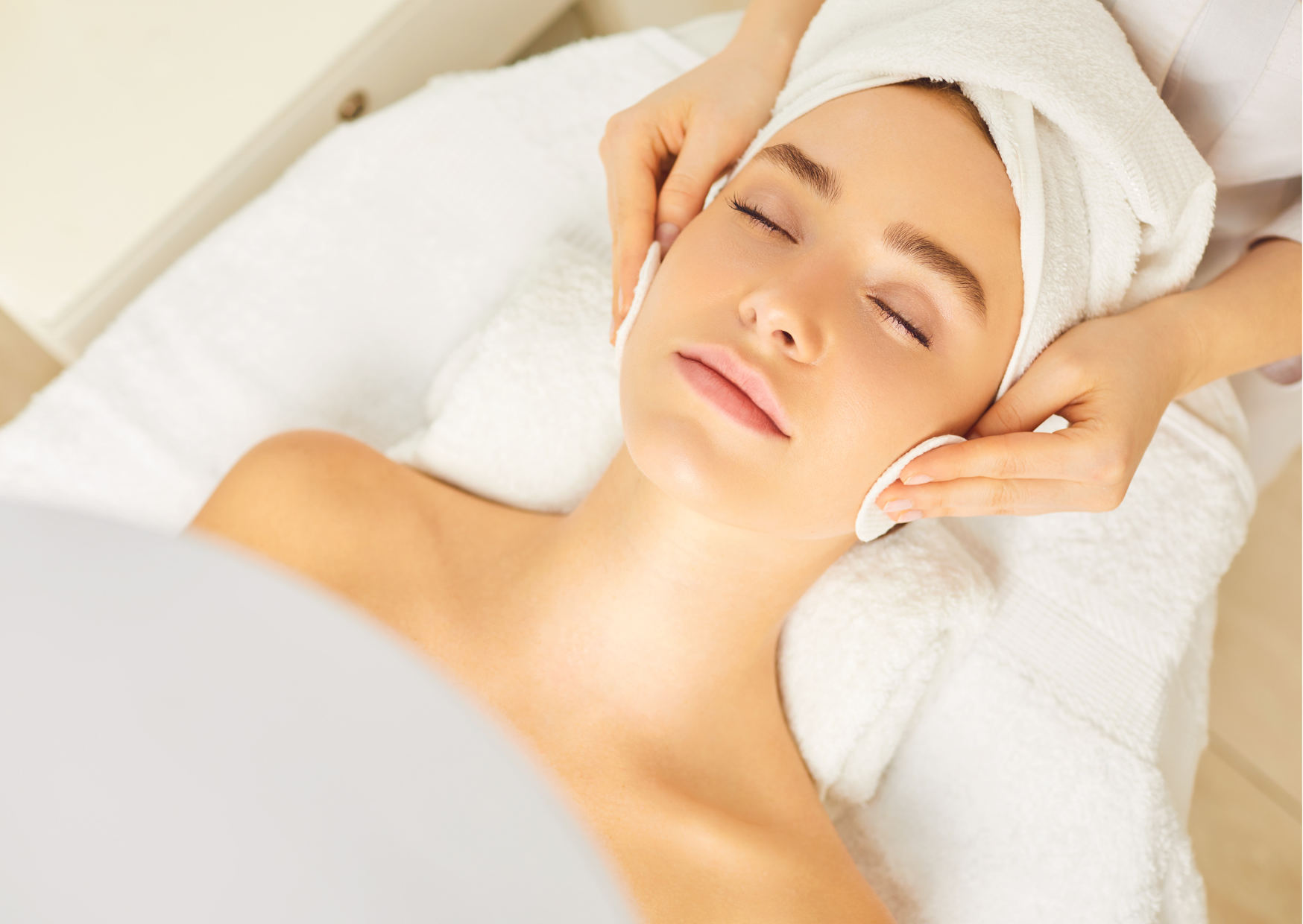 Woman receiving a relaxing facial massage from an esthetician during a professional skincare treatment.